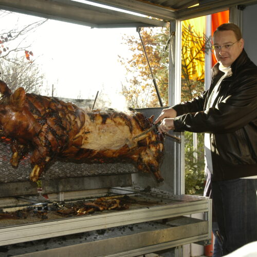 Weihnachtsbaumfest 2003 Elmar schneidet das Spanferkel an.
